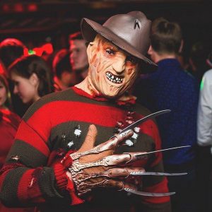 Человек в костюме Фредди Крюгера на вечеринке Хэллоуин
