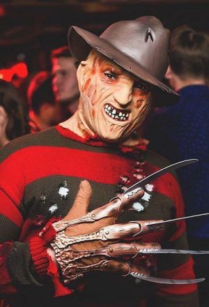Человек в костюме Фредди Крюгера на вечеринке Хэллоуин