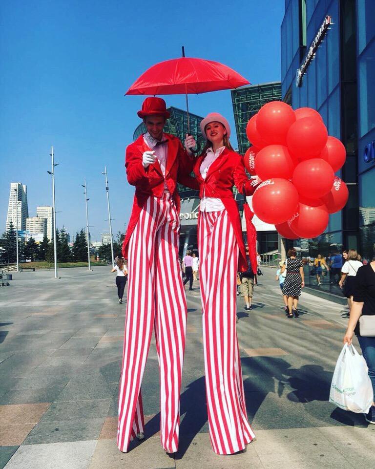 Ходулисты в красно-белых костюмах с воздушными шарами